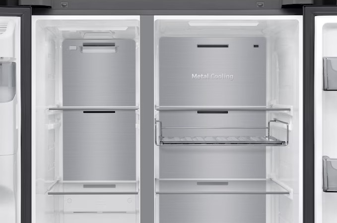 Pustą, otwartą lodówkę z metalowymi panelami chłodzącymi. Widoczne półki. Prawe drzwi mają drucianą półkę.