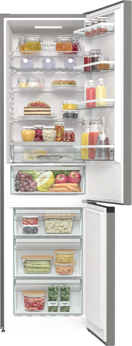 Otwarta lodówka wypełniona jedzeniem: słoiki, ciasto, owoce i warzywa. Drzwi lodówki są otwarte.