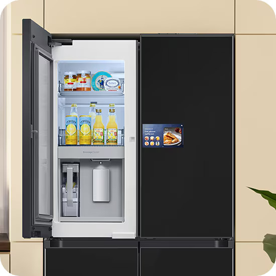 Czarna lodówka z otwartymi drzwiami, w których widać jedzenie i napoje. Drzwi mają ekran. Tło to beżowa ściana.
