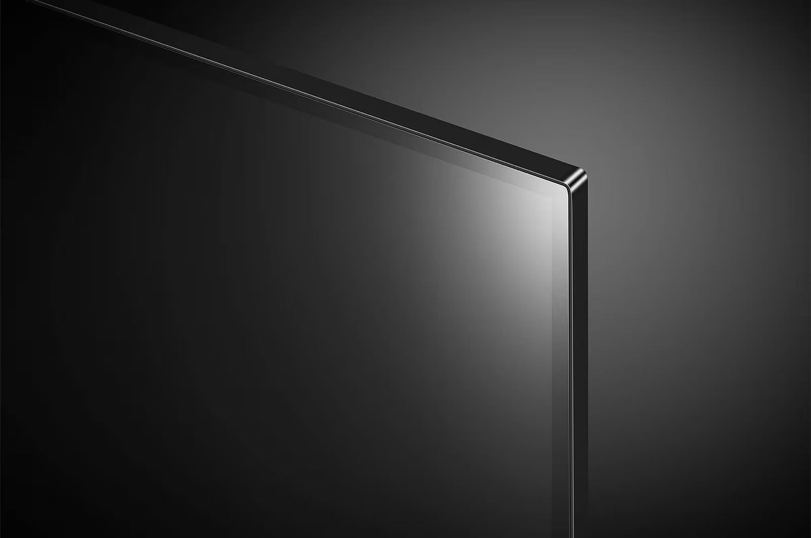 Nahaufnahme eines dunklen, modernen Fernsehers. Der Bildschirm ist schwarz und reflektiert Licht. Der Rahmen ist dünn und metallisch. Der Hintergrund ist ein Grauton.
