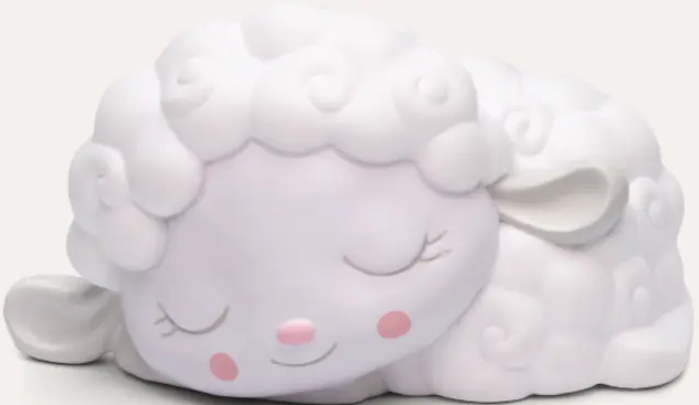 Una luce notturna a forma di pecora bianca che dorme. Ha gli occhi chiusi, le guance rosa e il naso rosa. Lo sfondo è bianco.