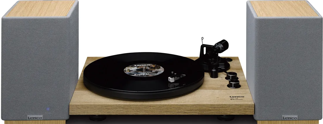 Giradischi con altoparlanti. Un disco sul giradischi. Gli altoparlanti sono grigi e color legno. Il giradischi è su una base di legno.