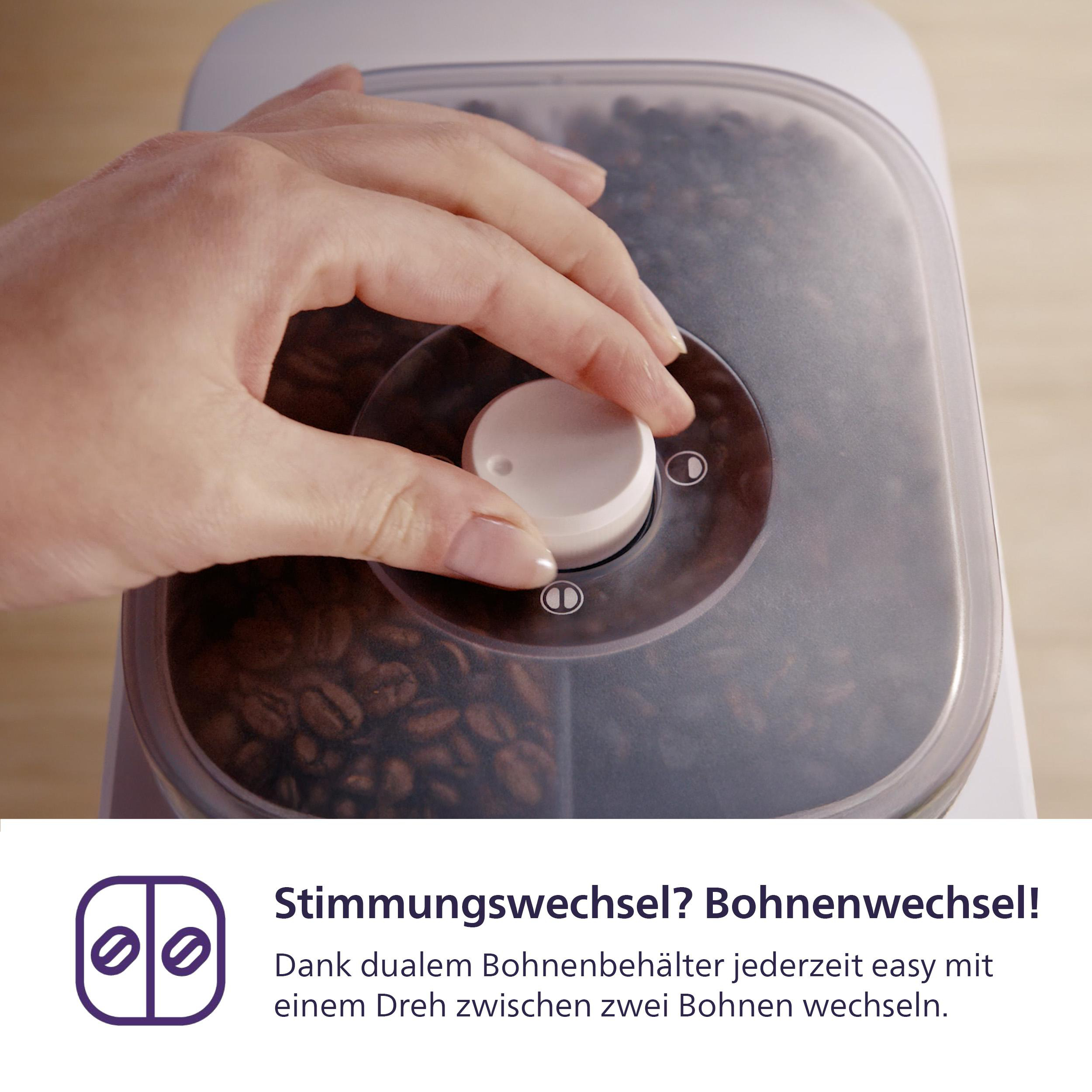 Eine Hand dreht einen weißen Drehknopf auf einem Kaffeebehälter. Der Behälter ist klar, und Kaffeebohnen sind sichtbar.