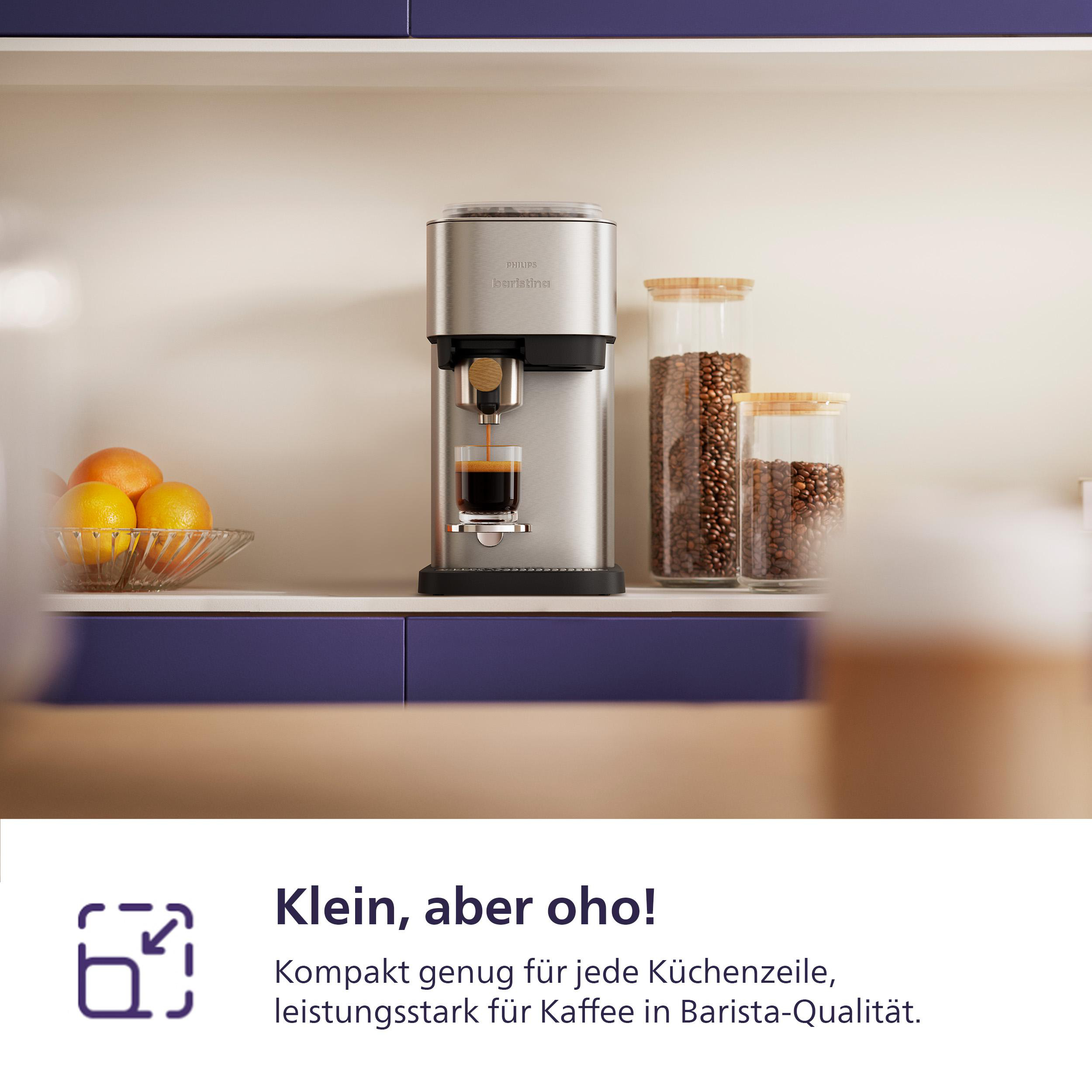 Eine silberne Kaffeemaschine brüht Kaffee in eine Glastasse. Orangen in einer Glasschale. Kaffeebohnen in Gläsern.