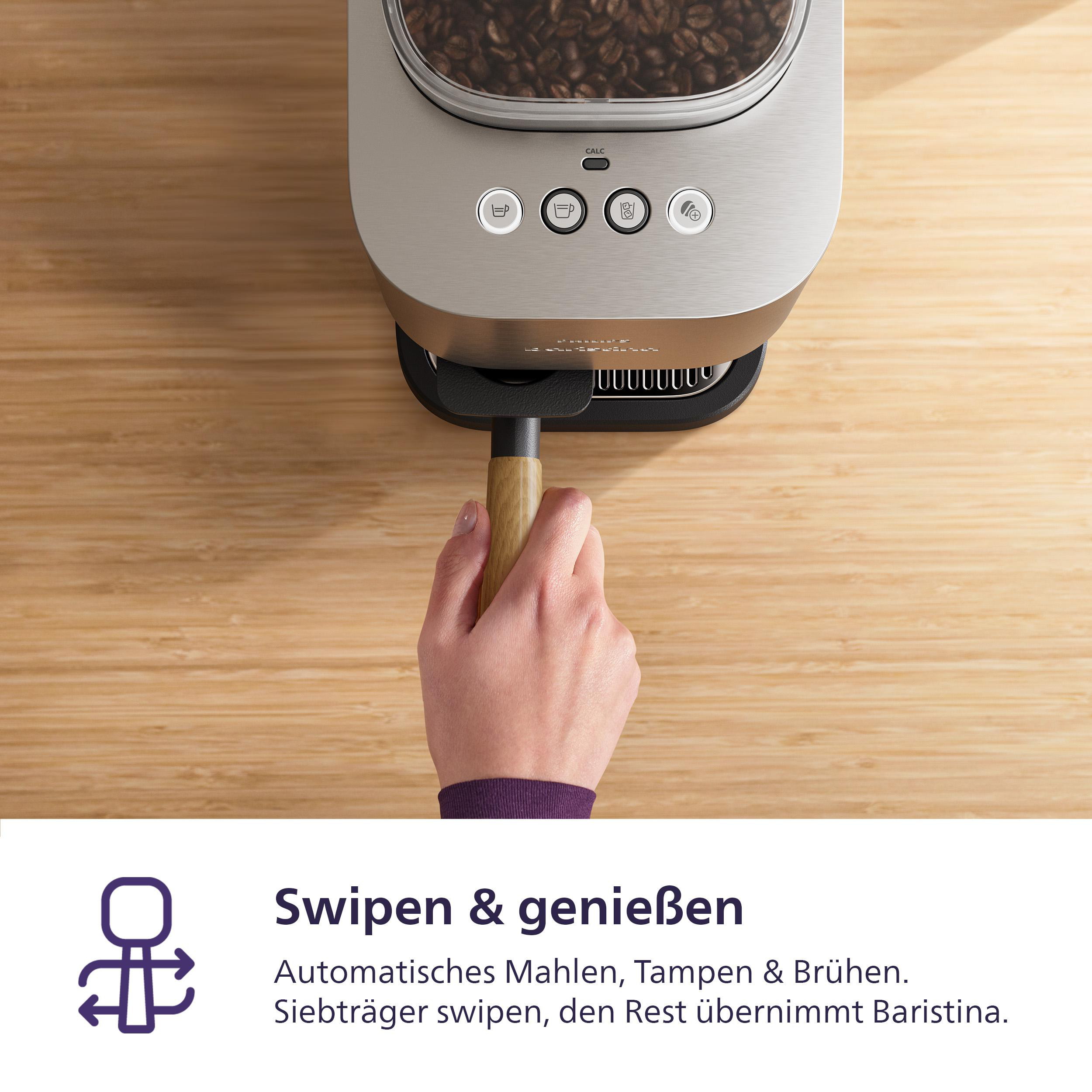 Eine Hand hält den Holzgriff einer Kaffeemaschine. Die Maschine hat Knöpfe, und Kaffeebohnen sind sichtbar.