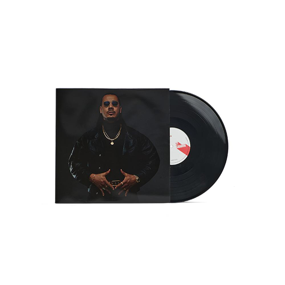 Eine Schallplatte mit einem Cover, das einen Mann mit Sonnenbrille und schwarzer Jacke, Schmuck und einem schwarzen Rollkragenpullover zeigt.