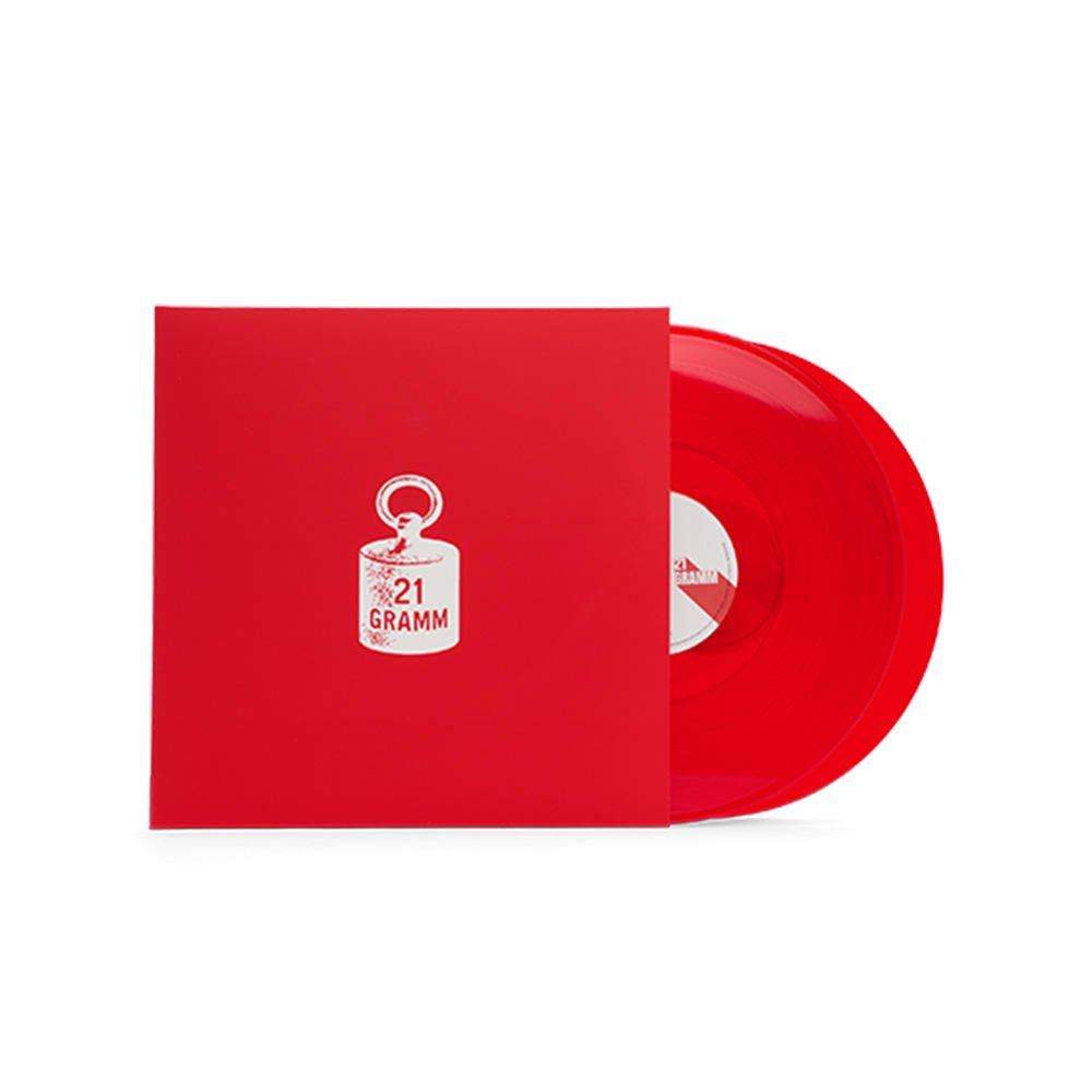 Eine rote Schallplatte lugt aus ihrer roten Hülle. Die Hülle hat ein weißes Logo mit '21 GRAMM'. Das Plattenlabel ist sichtbar.