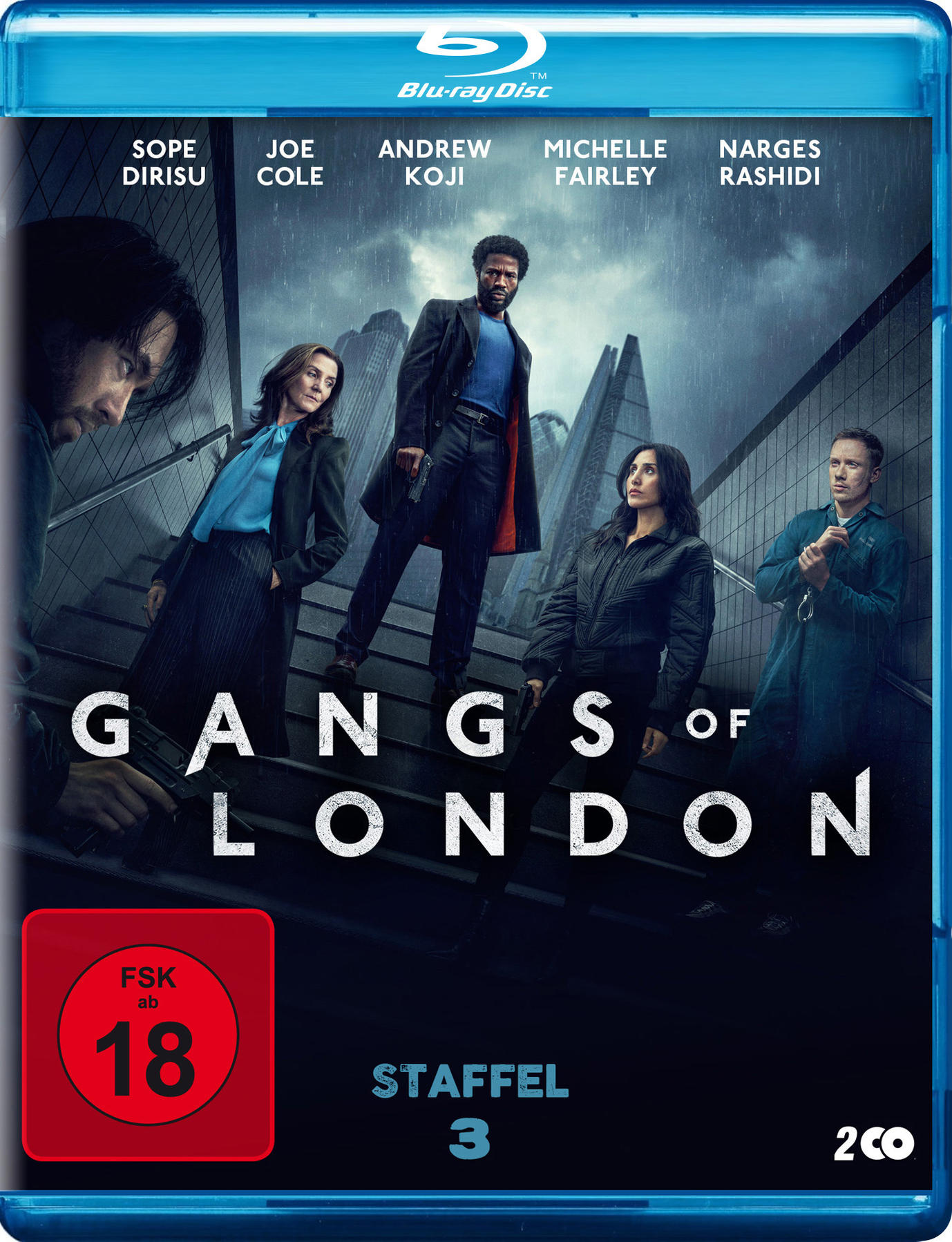 Blu-ray-Cover von Gangs of London. Fünf Personen auf einer Treppe, ein Mann in der Mitte mit einer Waffe, Regen im Hintergrund.