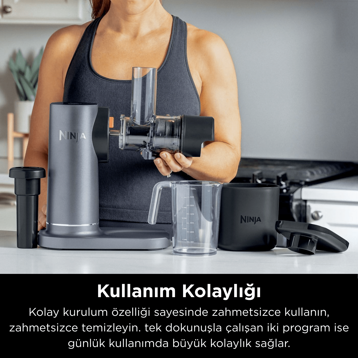 Bir kadın, beyaz bir yüzeyde çeşitli parçaları olan bir sıkacağı tutuyor. Sıkacak gri ve siyahtır. NINJA kelimesi görülebilir.