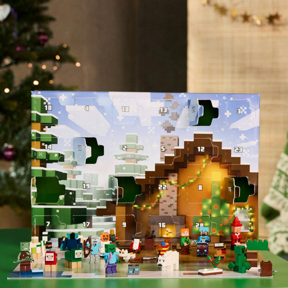 Minecraft-Adventskalender mit Figuren und Weihnachtsbaum. Schneebedeckte Szene mit offenen Türen, die Figuren zeigen. Grüner Tisch.
