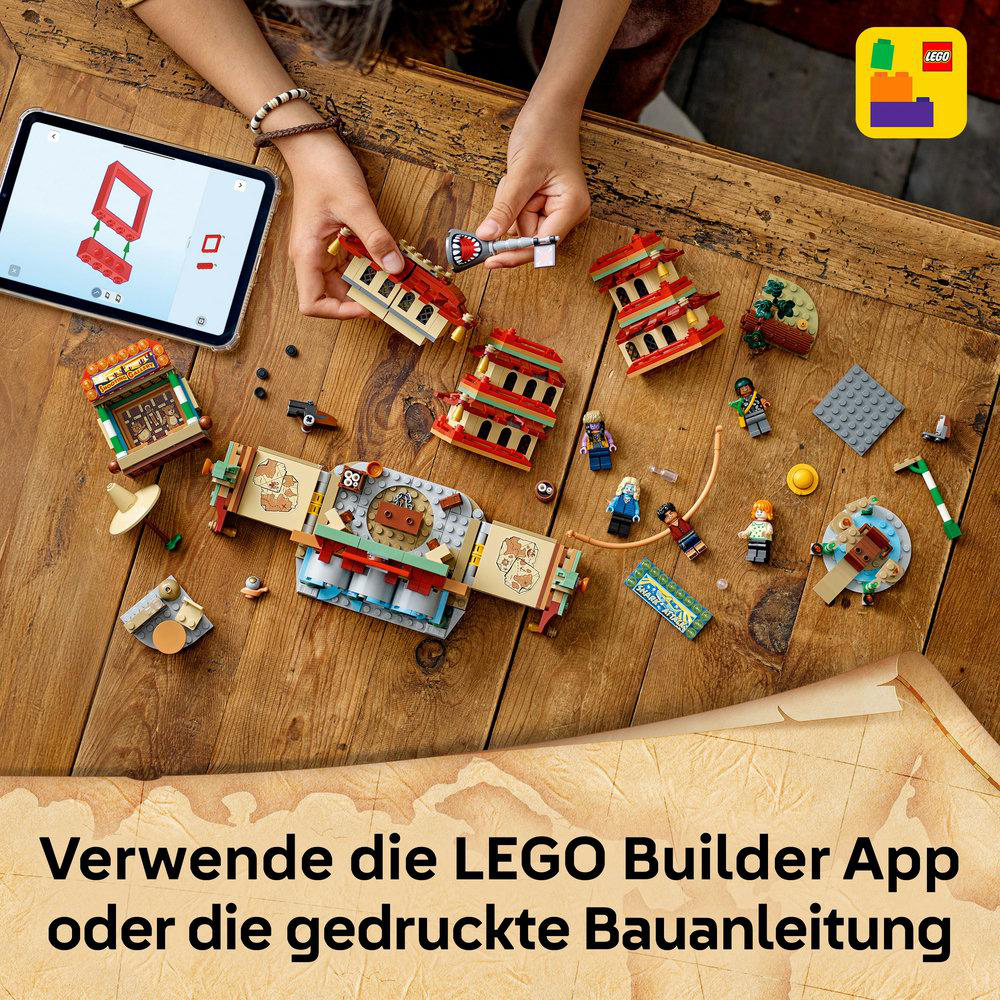 Lego-Set mit verschiedenen Teilen, Minifiguren und einem Tablet mit Anweisungen, alles auf einem Holztisch angeordnet.