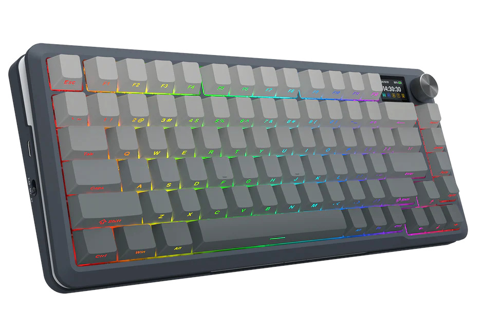 Szara klawiatura mechaniczna z podświetlanymi klawiszami. Ma mały ekran i pokrętło w prawym górnym rogu. Klawisze są jasnoszare.