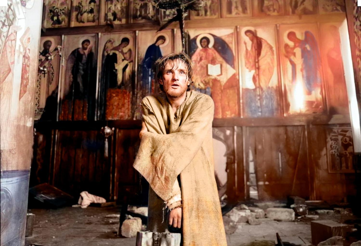 Mann in Robe steht in Kirche. Ikonen an der Wand. Trümmer auf dem Boden. Er blickt mit überraschtem Gesichtsausdruck nach oben.