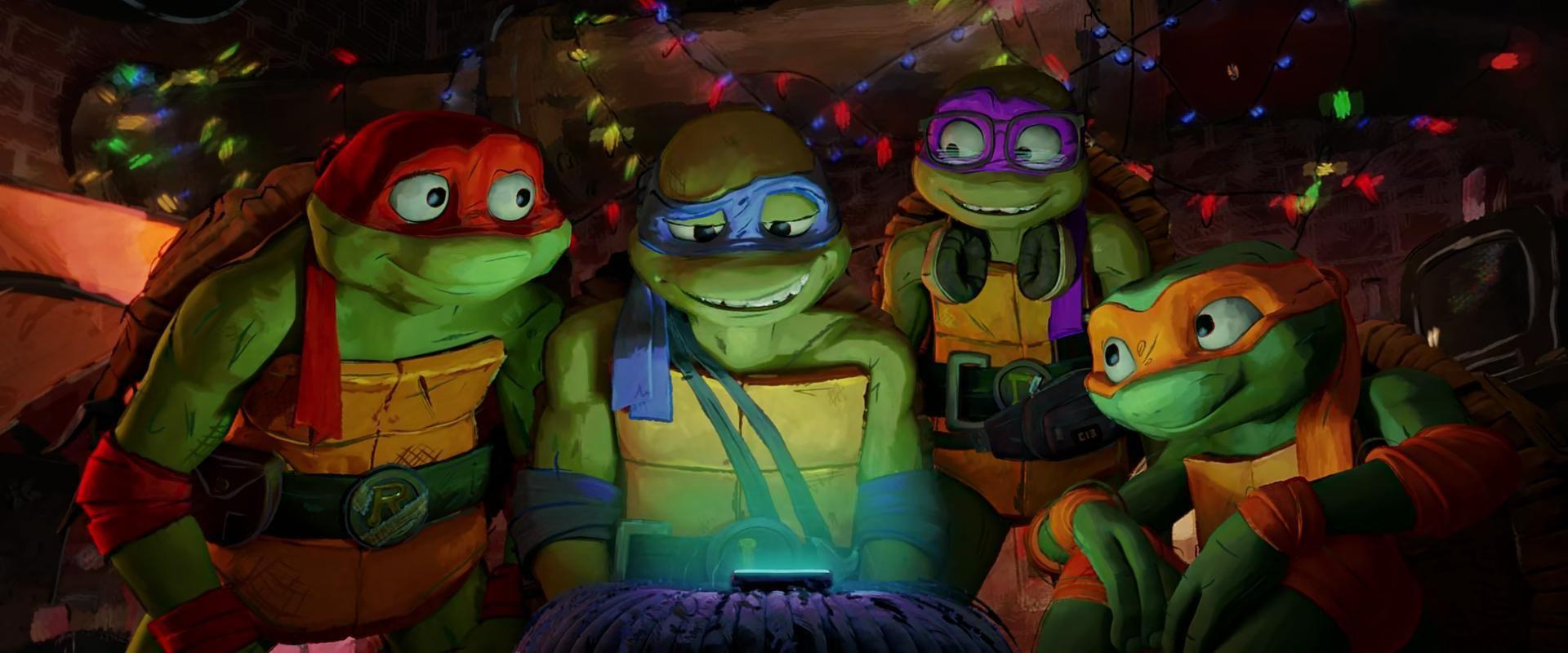 Vier Teenage Mutant Ninja Turtles schauen gemeinsam auf ein leuchtendes Gerät. Sie befinden sich in einem Raum mit Lichterketten.
