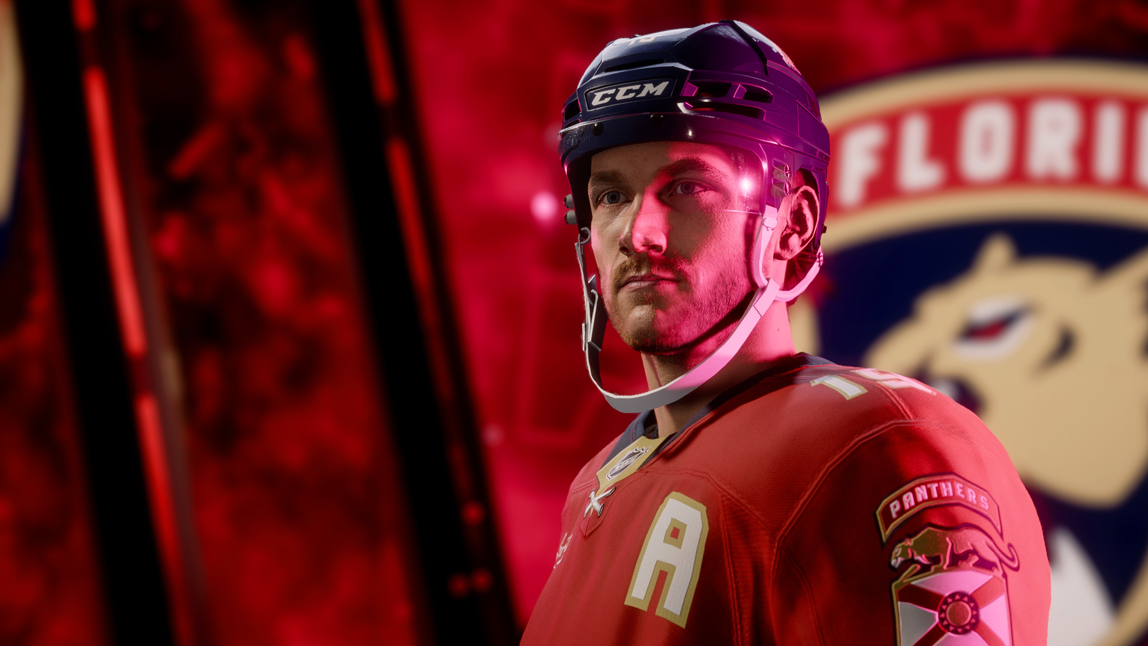 Ein Hockeyspieler in einem roten Trikot mit Helm. Der Hintergrund ist verschwommen, das Logo des Teams ist sichtbar.