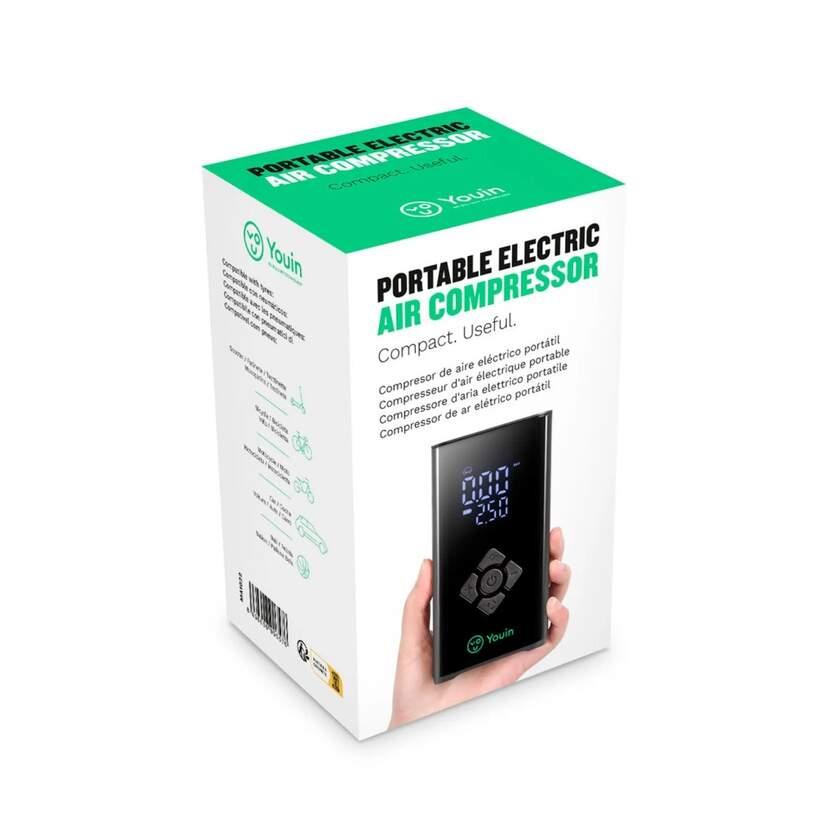 Caja con compresor de aire eléctrico portátil. Una mano sostiene el dispositivo negro. Fondo blanco.