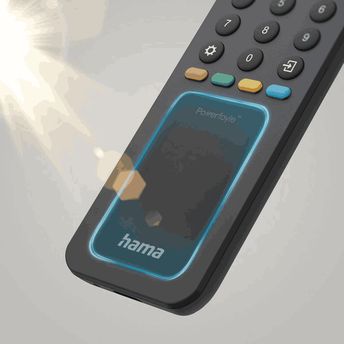 Primer plano de un mando a distancia Hama negro. Tiene botones con números y símbolos. Un área de pantalla táctil está delineada en azul.