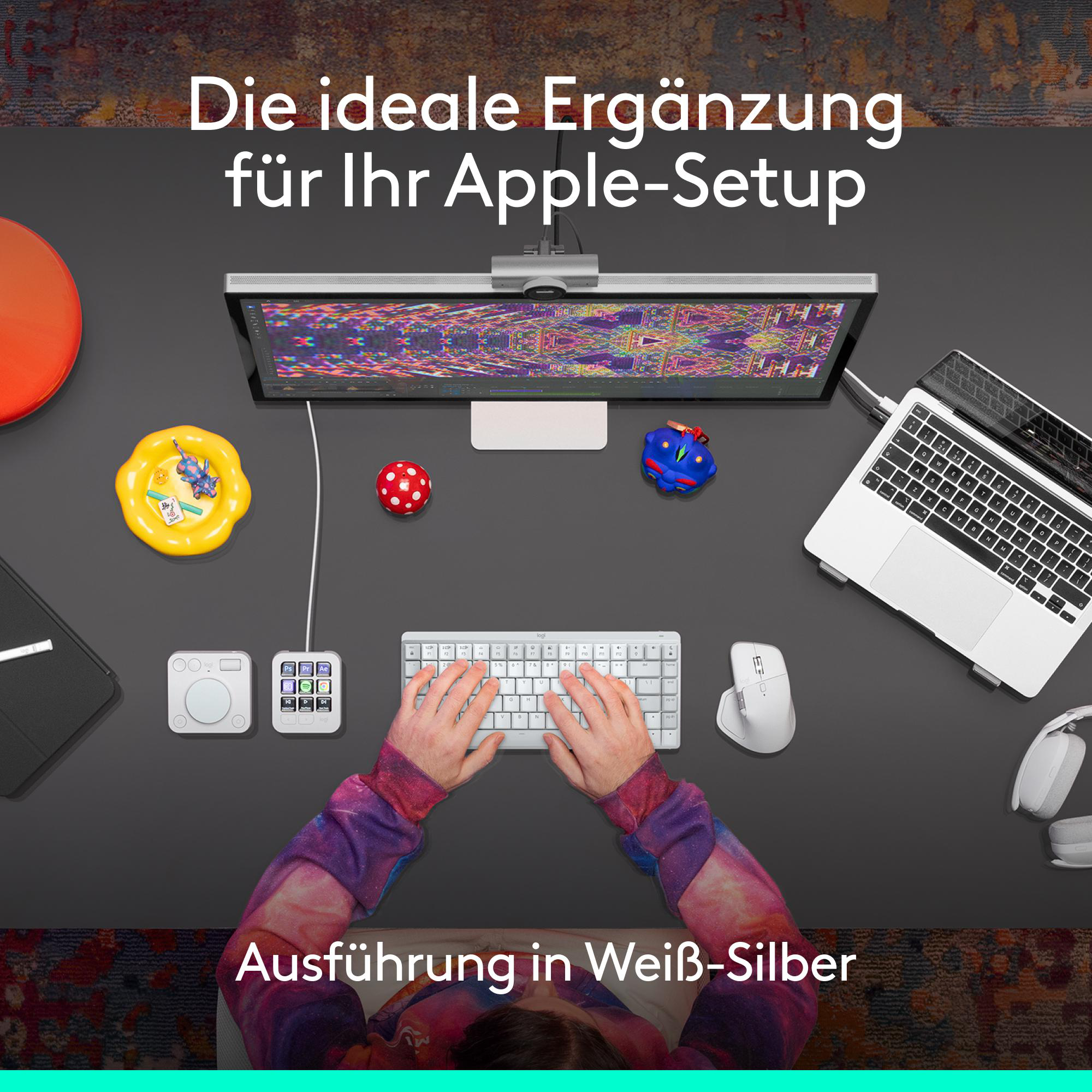 Draufsicht auf einen Schreibtisch mit Monitor, Tastatur, Maus und Zubehör. Hände tippen auf der Tastatur.
