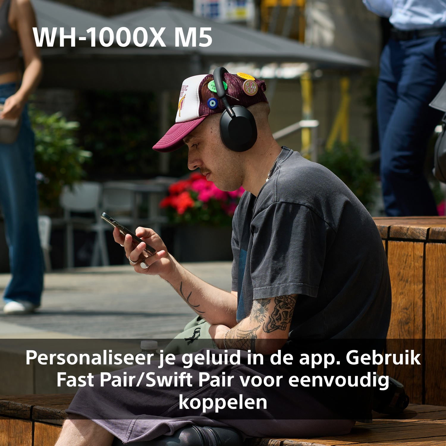 A man with headphones and a cap sits on a bench, looking at his phone. Text about sound personalization is below.