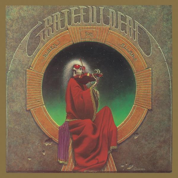 Vörös ruhás csontváz hegedül. A kép egy körben van, melyen a 'Grateful Dead' felirat szerepel.