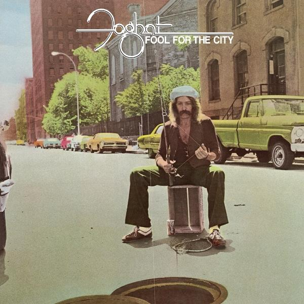 Bajuszos férfi egy dobozon ül, horgászbotot tart az utcán, autók a háttérben, album borító.