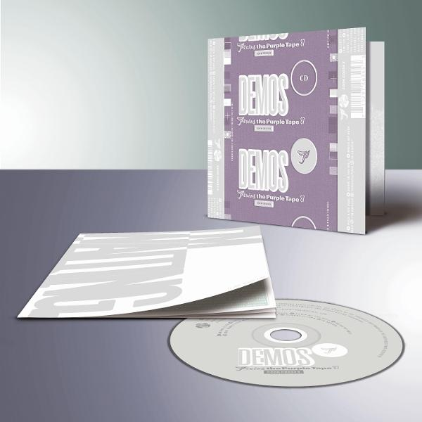 Eine CD-Hülle mit CD und Booklet. Die Hülle ist lila mit weißem Text "DEMOS". Die CD ist silberfarben. Das Booklet ist geöffnet.