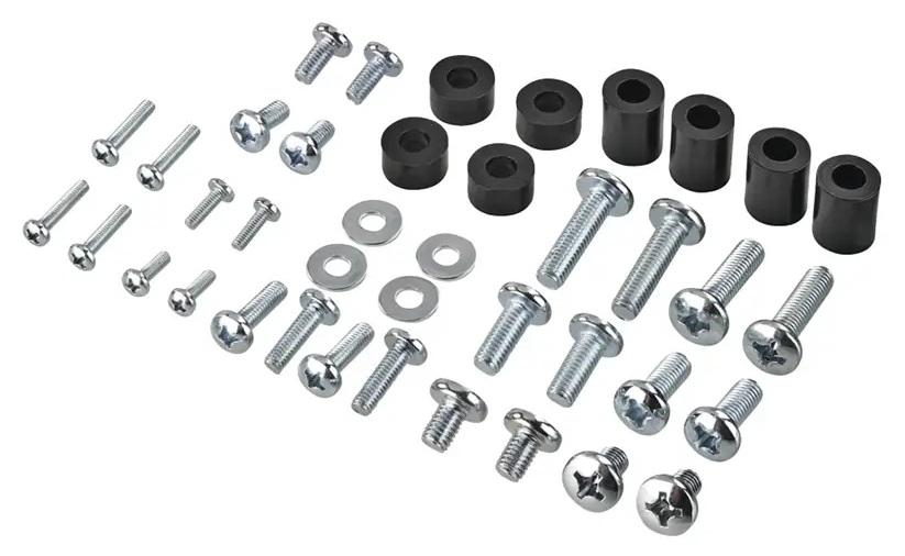 Różne śruby, podkładki i czarne cylindryczne dystanse są ułożone na białej powierzchni.
