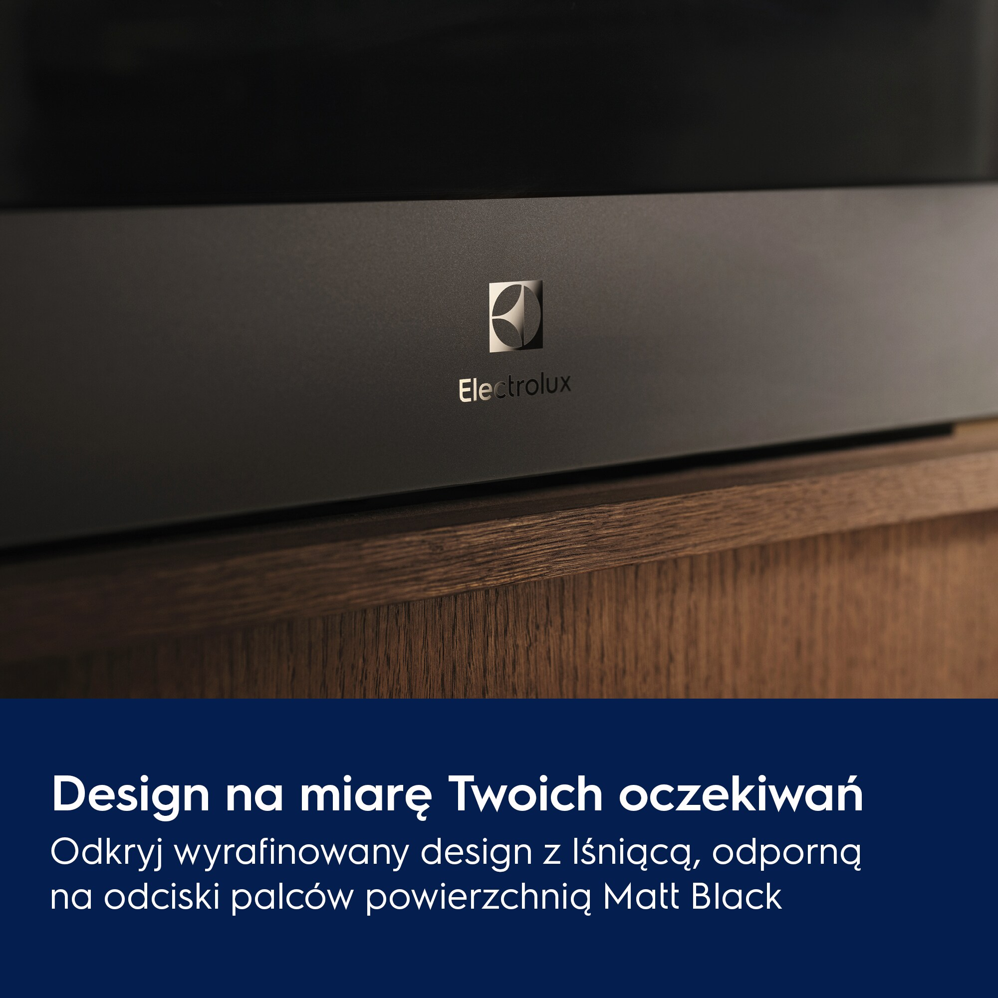 Zbliżenie czarnego urządzenia z logo Electrolux. Poniżej drewniana powierzchnia. Widoczny jest tekst w języku polskim.