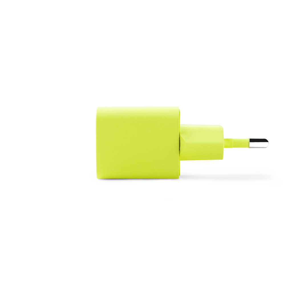 USB-C portlu neon yeşili bir şarj cihazı. Dikdörtgen bir gövdeye sahip ve beyaz bir yüzey üzerinde duruyor.