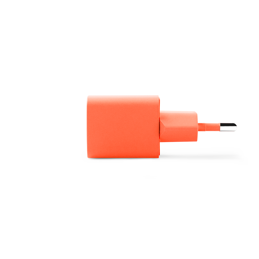 Beyaz zemin üzerinde, dikdörtgen gövdeli ve USB-C konektörlü turuncu güç adaptörü. Adaptör açılı duruyor.
