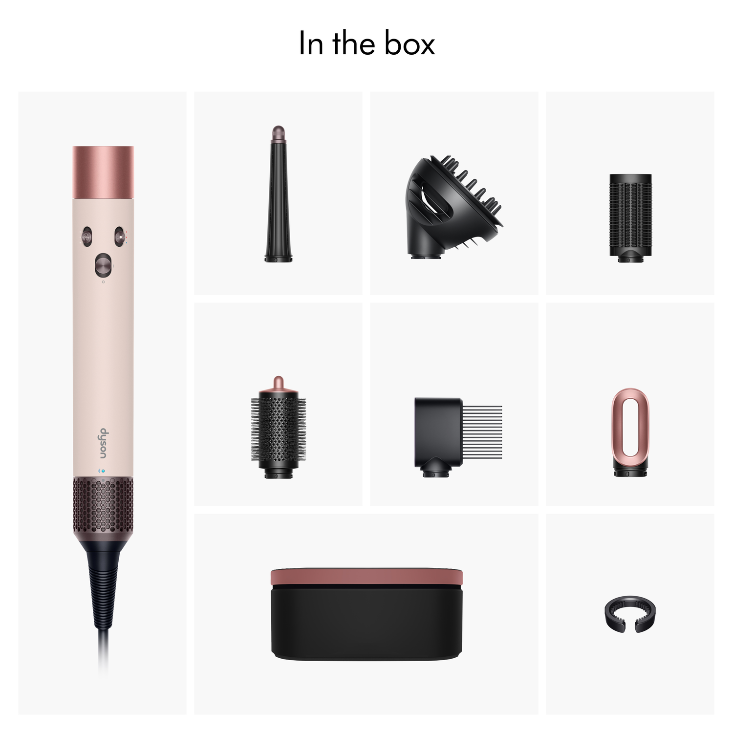 The image shows a hair styler with attachments. The styler is pink and copper. Other attachments are black. All are on a white background.
