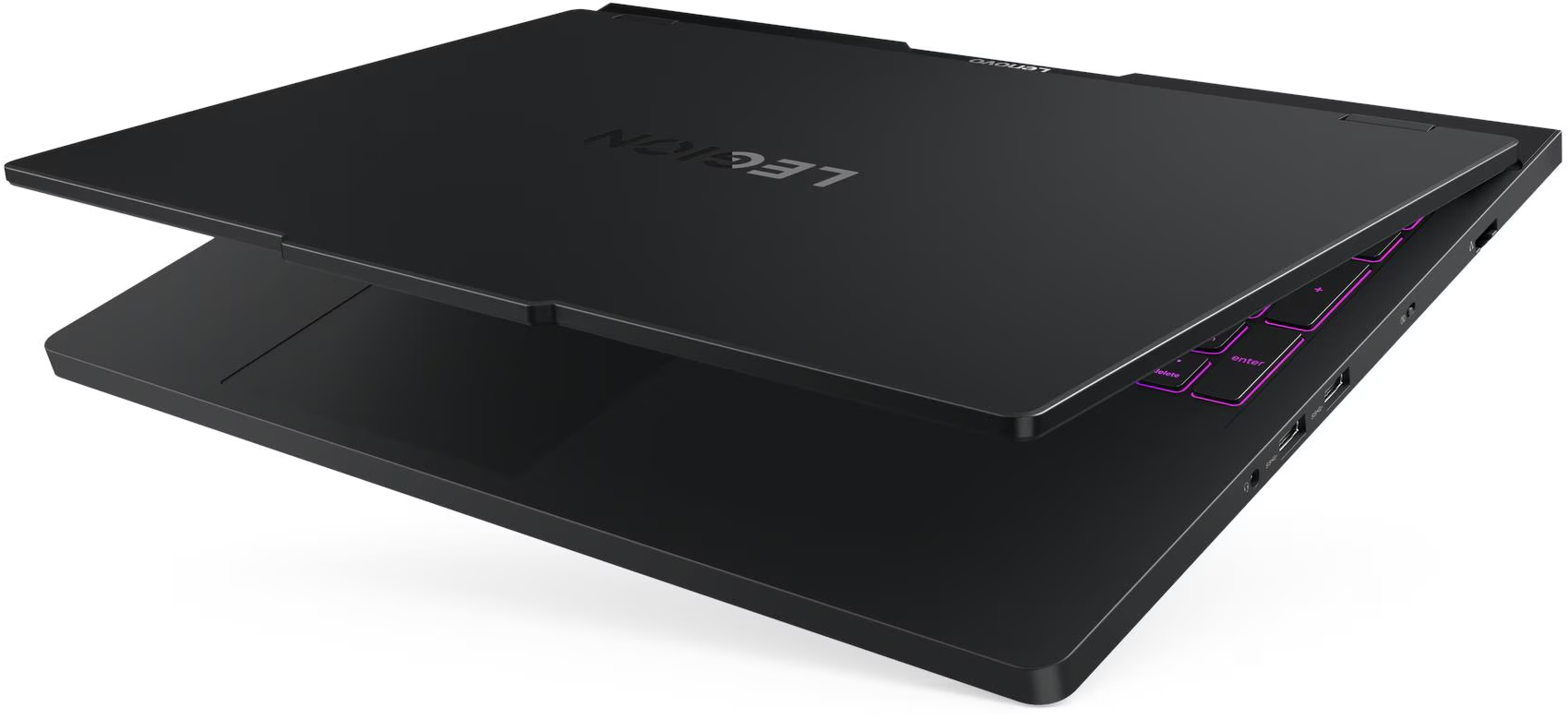 Egy fekete Lenovo Legion laptop nyitva van. A billentyűzet látható, a gombok lilával világítanak. A Legion logó látható.