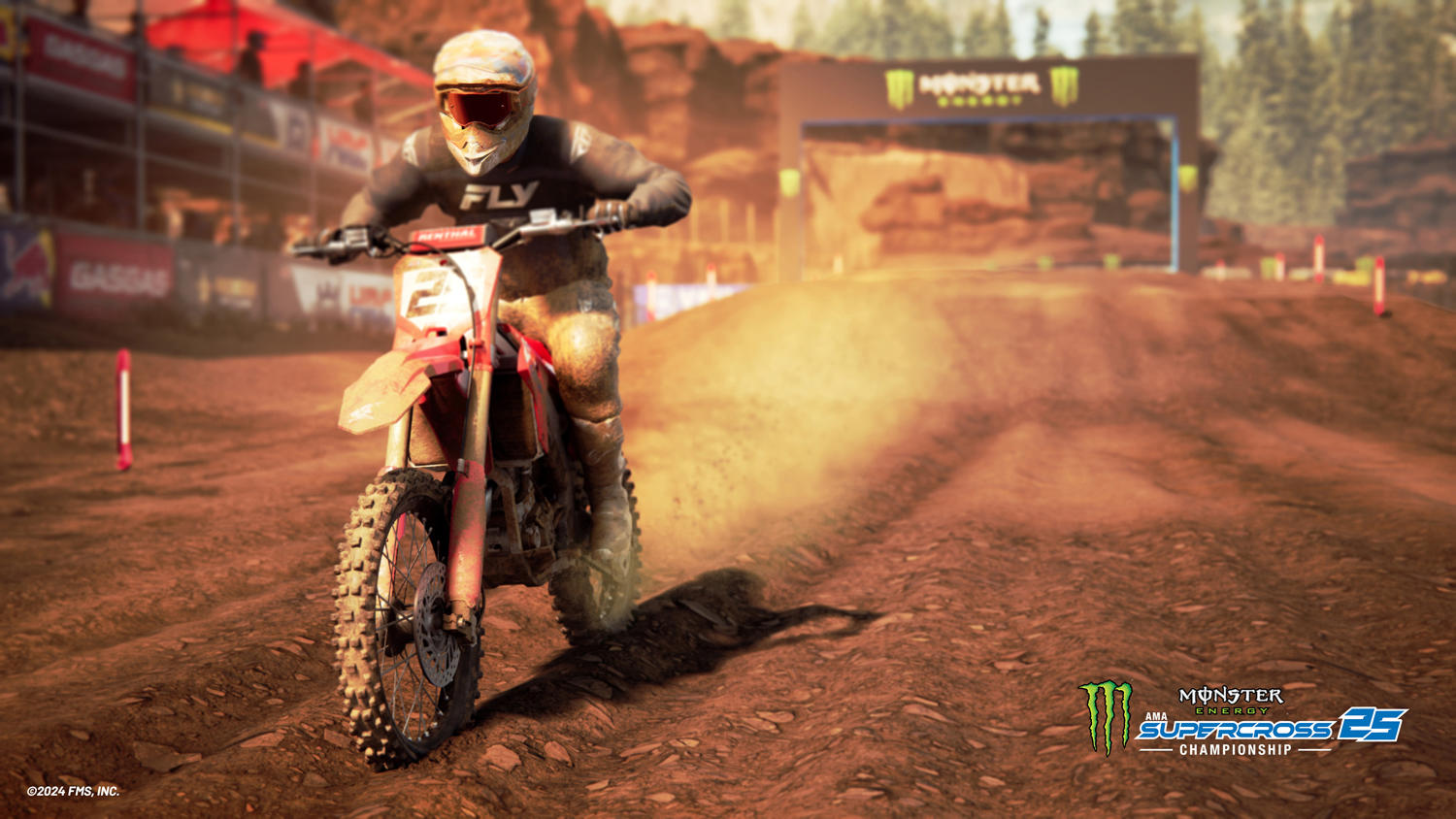 Ein Motocross-Rennfahrer auf einem rot-weißen Motorrad fährt über eine Dirt-Strecke. Die Szene ist ein Rennen, mit einem Monster Energy-Bogen.