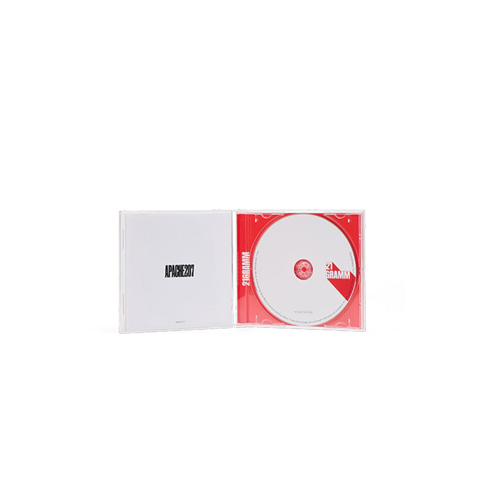 Geöffnete CD-Hülle mit weißer Disc. Hülle hat Text 'APACHE207'. Die Disc hat '21 GRAMM' aufgedruckt.