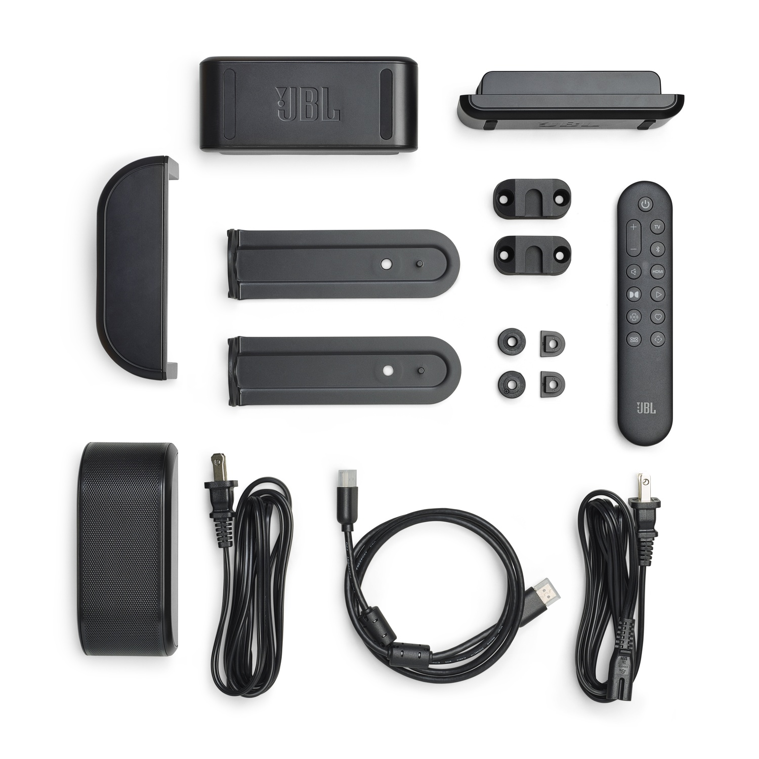 Composants noirs de la barre de son JBL sur fond blanc : barre de son, télécommande, câbles d'alimentation, supports et accessoires.