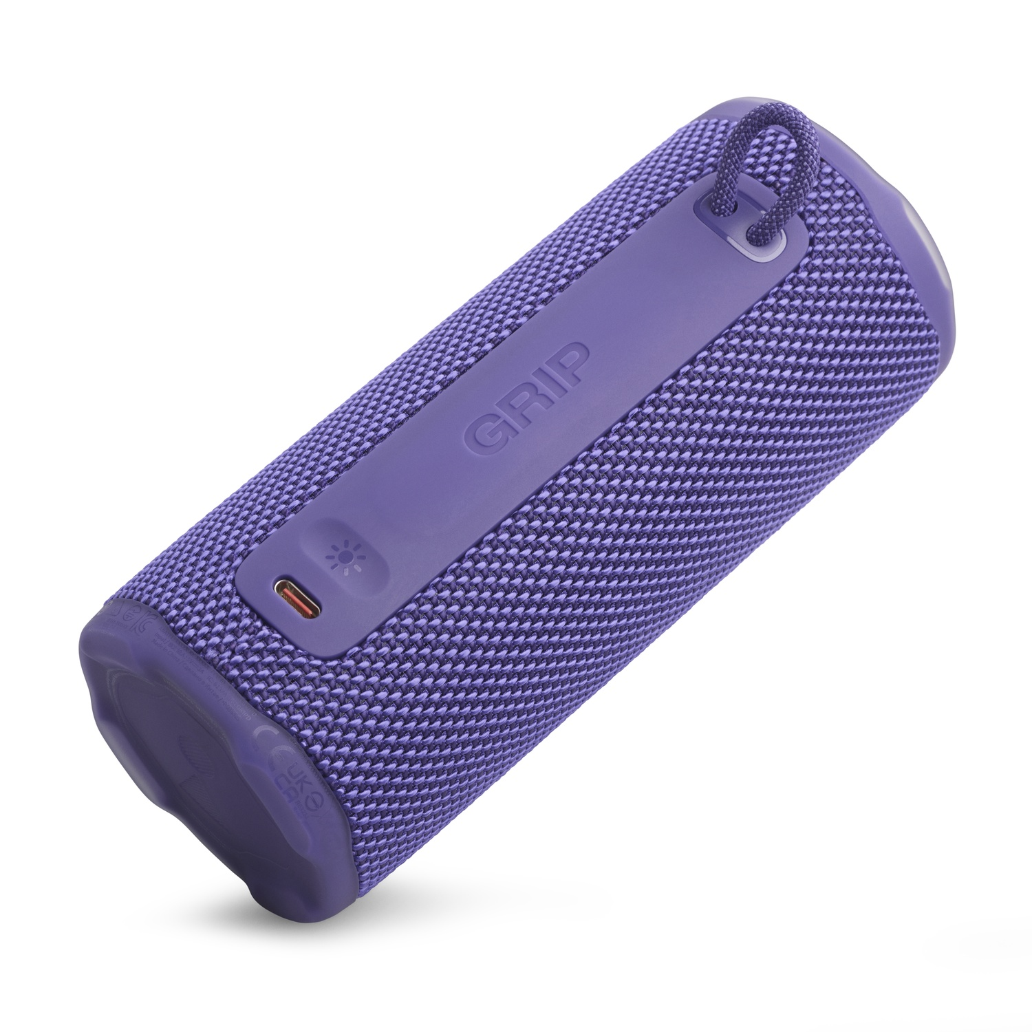 Un haut-parleur cylindrique violet avec une texture en tissu. Il a une boucle, un port USB-C et le mot 'GRIP'. Le fond est blanc.