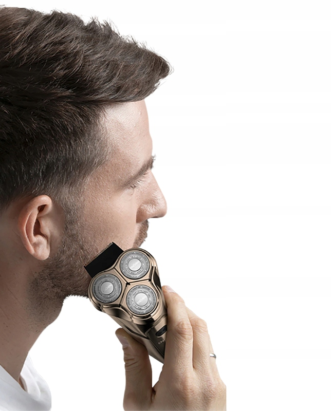 Mężczyzna goli brodę golarką elektryczną. Golarka jest w kolorze złotym i ma trzy okrągłe ostrza.