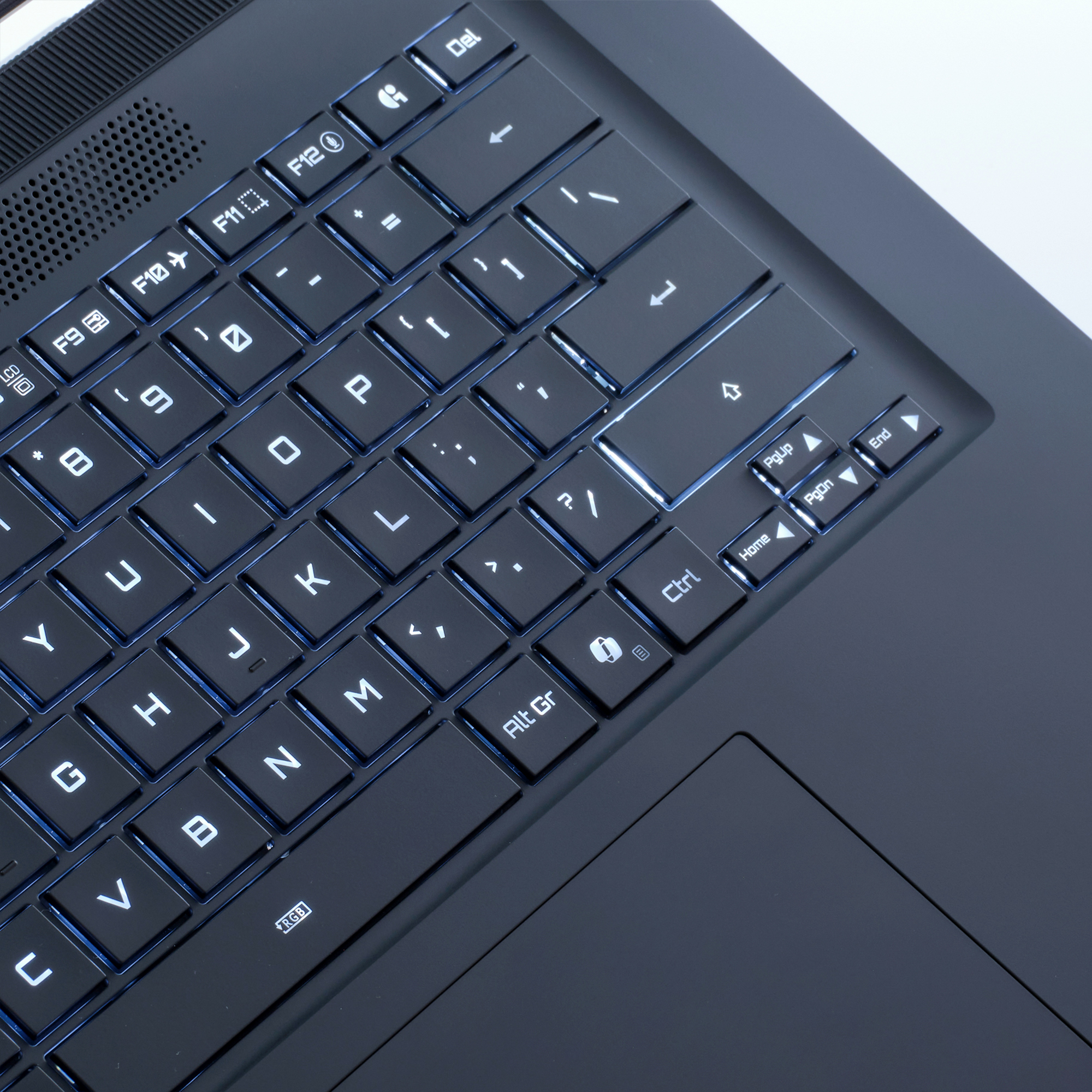 Nahaufnahme einer Laptop-Tastatur mit Hintergrundbeleuchtung. Buchstaben und Symbole sind sichtbar. Das Touchpad ist unten rechts.