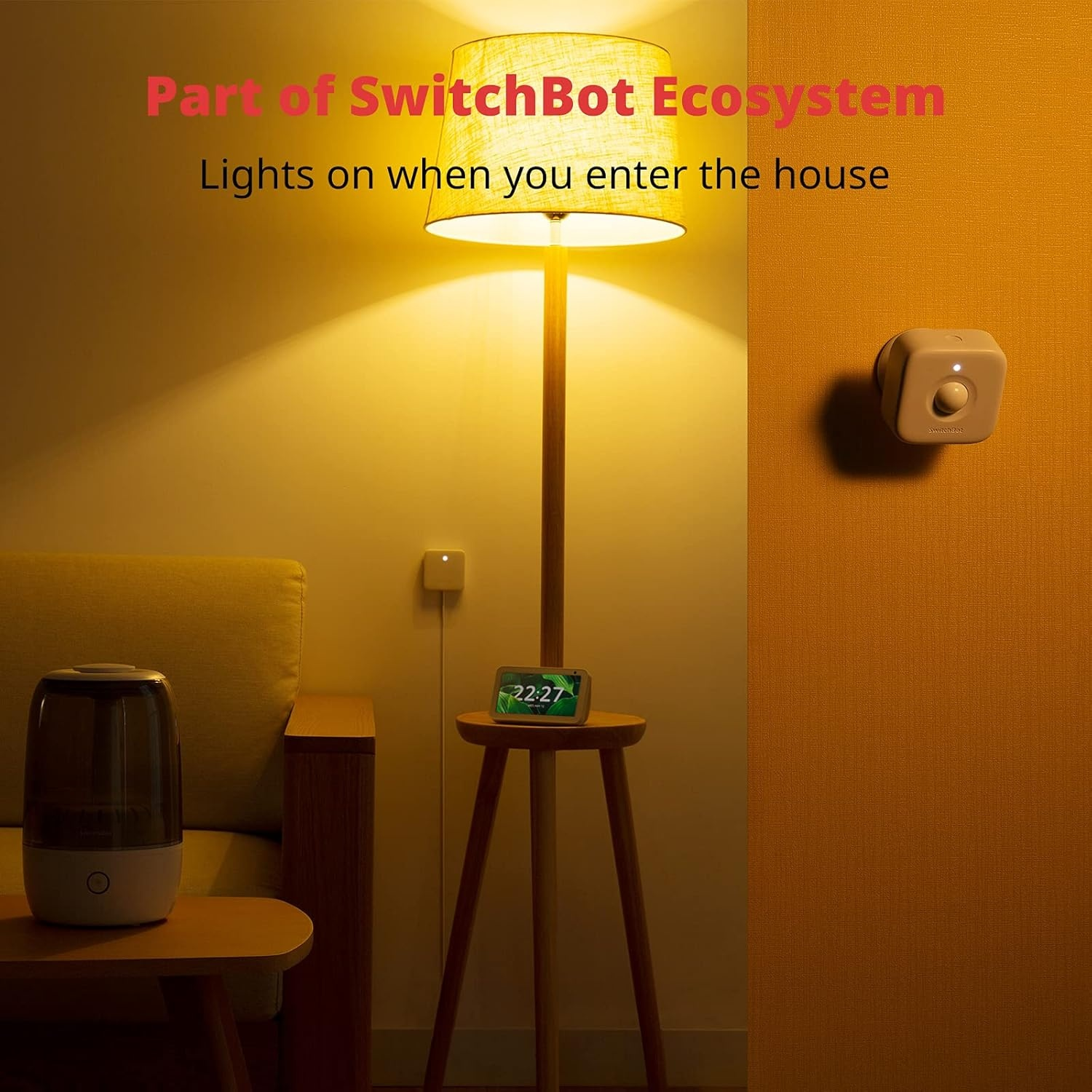 Scena di soggiorno con lampada accesa, dispositivo smart home e umidificatore. Testo: le luci si accendono quando entri in casa.