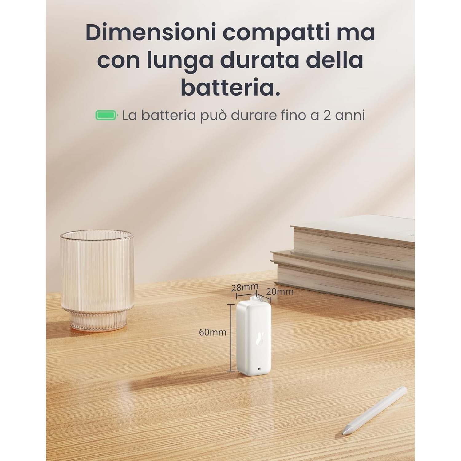 Un dispositivo bianco, un bicchiere e libri su un tavolo di legno. Sono indicate le dimensioni del dispositivo. Testo in italiano.