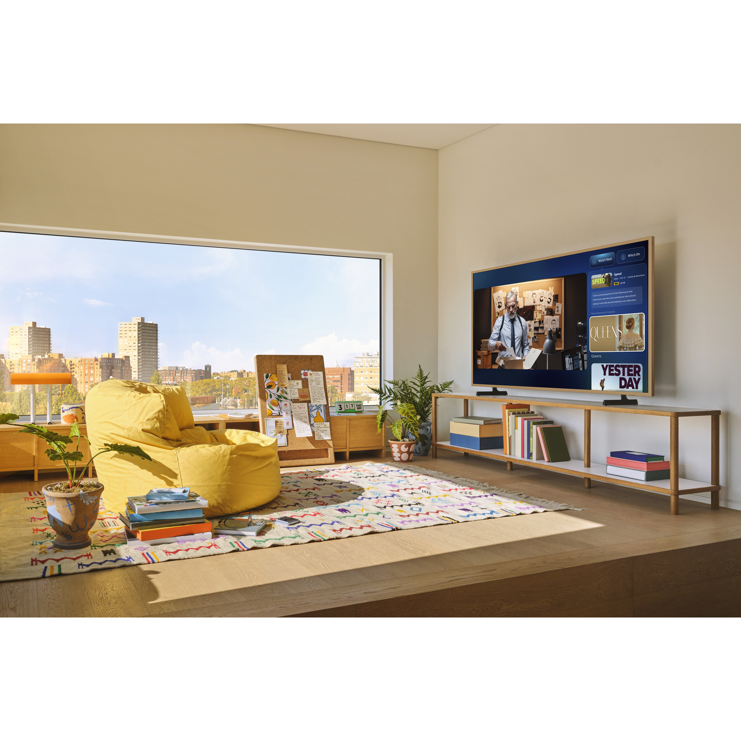 A modern living room features a large window with a city view. A yellow beanbag chair sits on a colorful rug. A TV displays a show.