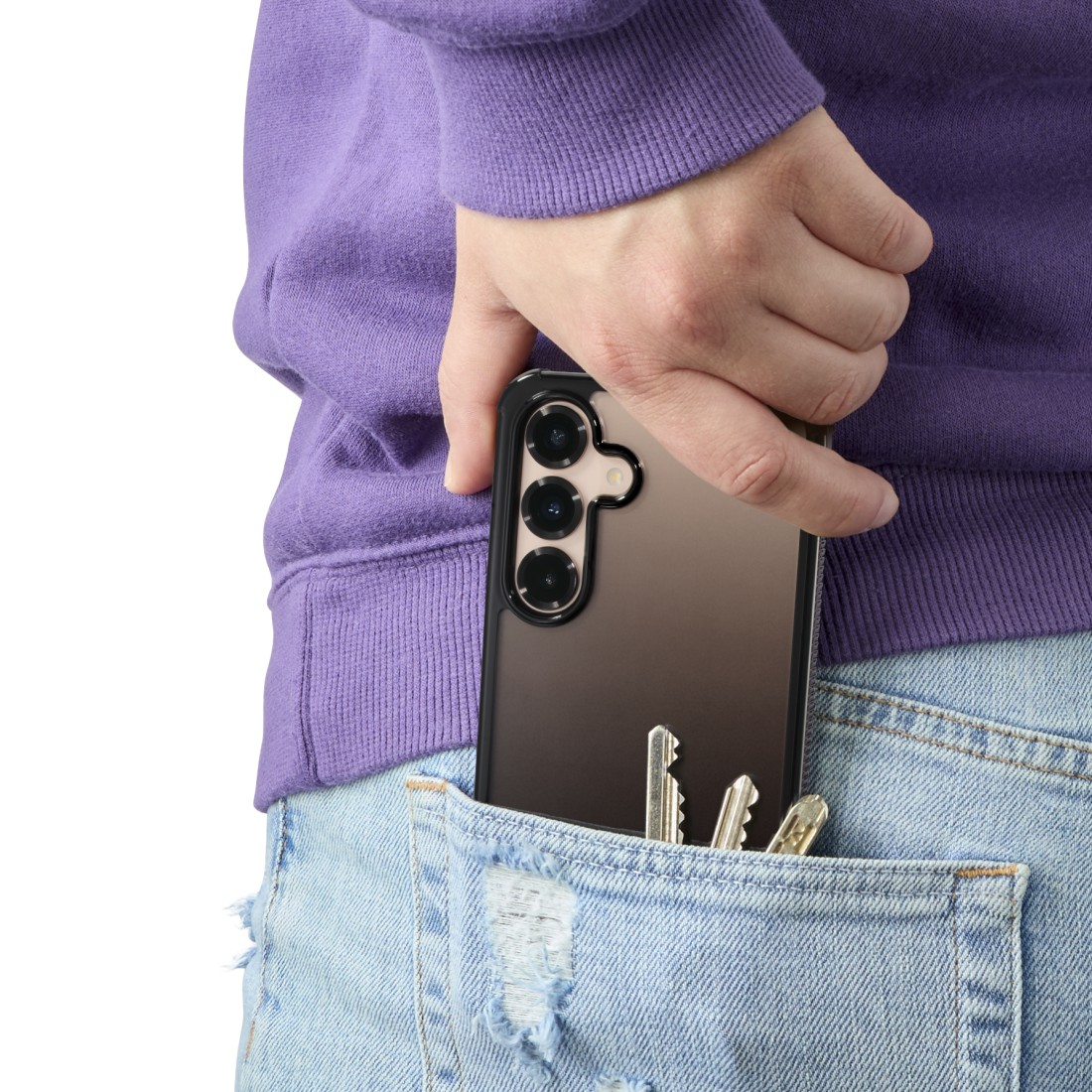 Hand hält ein Telefon in einer Tasche. Schlüssel befinden sich ebenfalls in der Tasche. Die Person trägt einen lila Kapuzenpulli und Jeans.