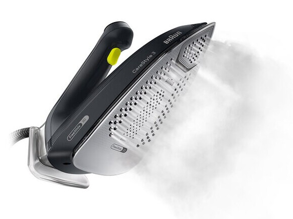 Czarne żelazko Braun z parą. Ma żółty przycisk i srebrną stopę. Tło jest białe.