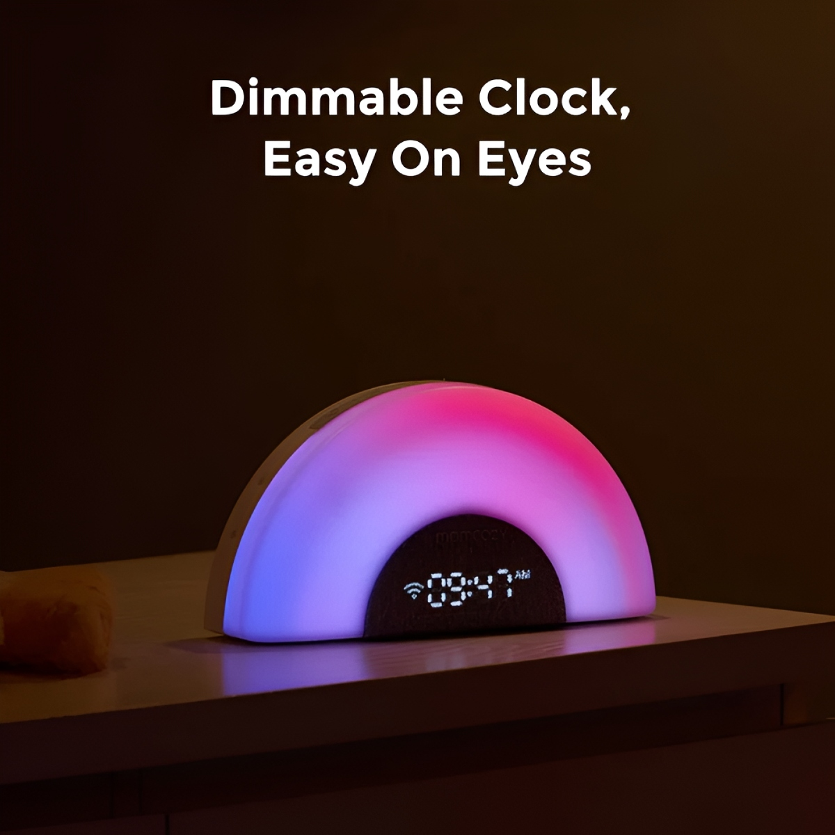 Eine regenbogenförmige Uhr mit digitaler Anzeige steht auf einem Nachttisch. Sie wird mit rosa und blauem Licht beleuchtet. Text oben sagt 'Dimmbare Uhr, schonend für die Augen'.