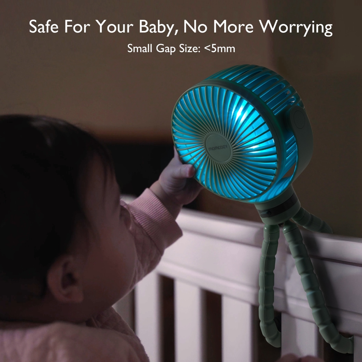 Ein Baby greift nach einem grünen Ventilator mit blauem Licht, der an einem Krippengeländer befestigt ist. Text sagt 'Sicher für Baby, keine Sorge'.