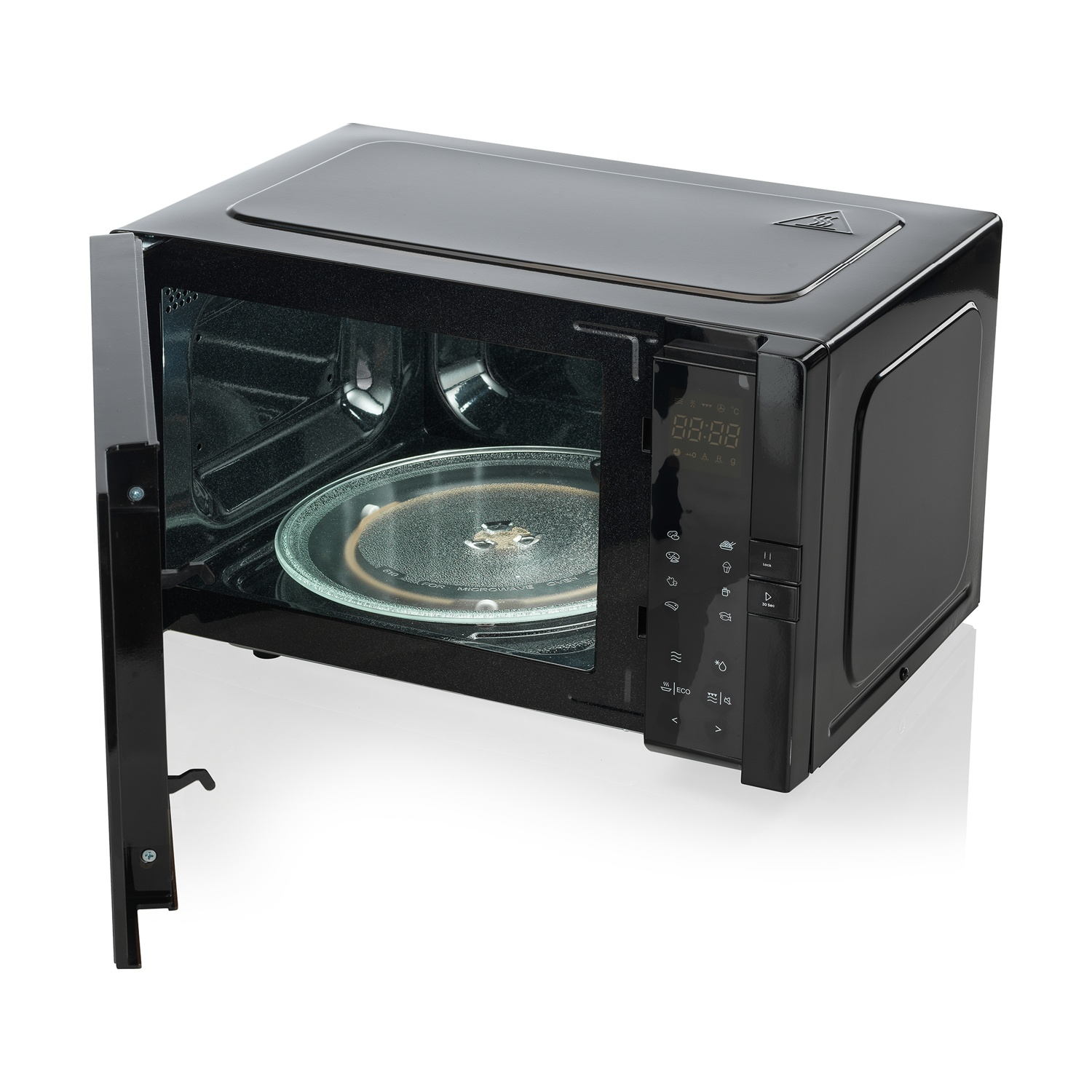 Un forno a microonde nero aperto mostra un piatto di vetro all'interno. Il forno è su una superficie bianca.