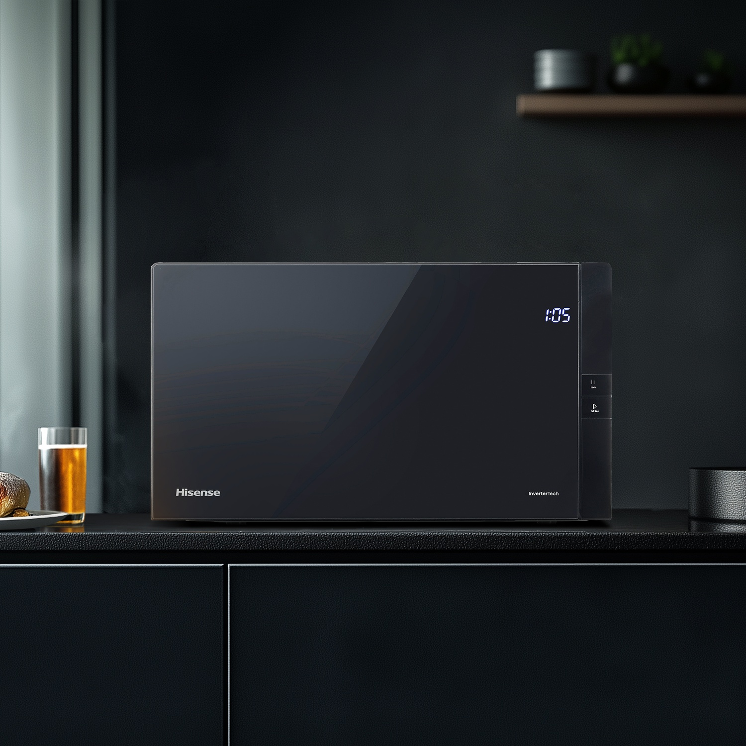 Microonde Hisense nero con display digitale. L'ora indica 1:05. Bicchiere di birra e piattino a sinistra.