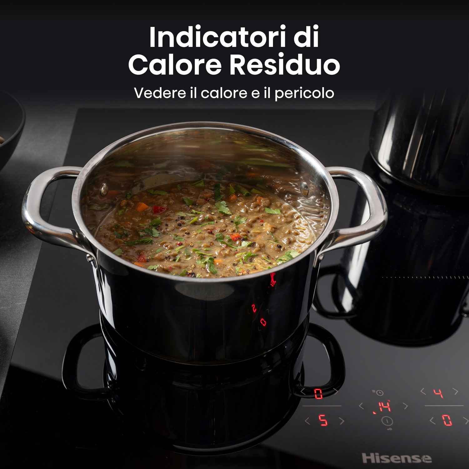Una pentola di zuppa su un piano cottura nero con display digitali. Il piano cottura ha indicatori di calore residuo. Il testo dice 'Calore Residuo'.
