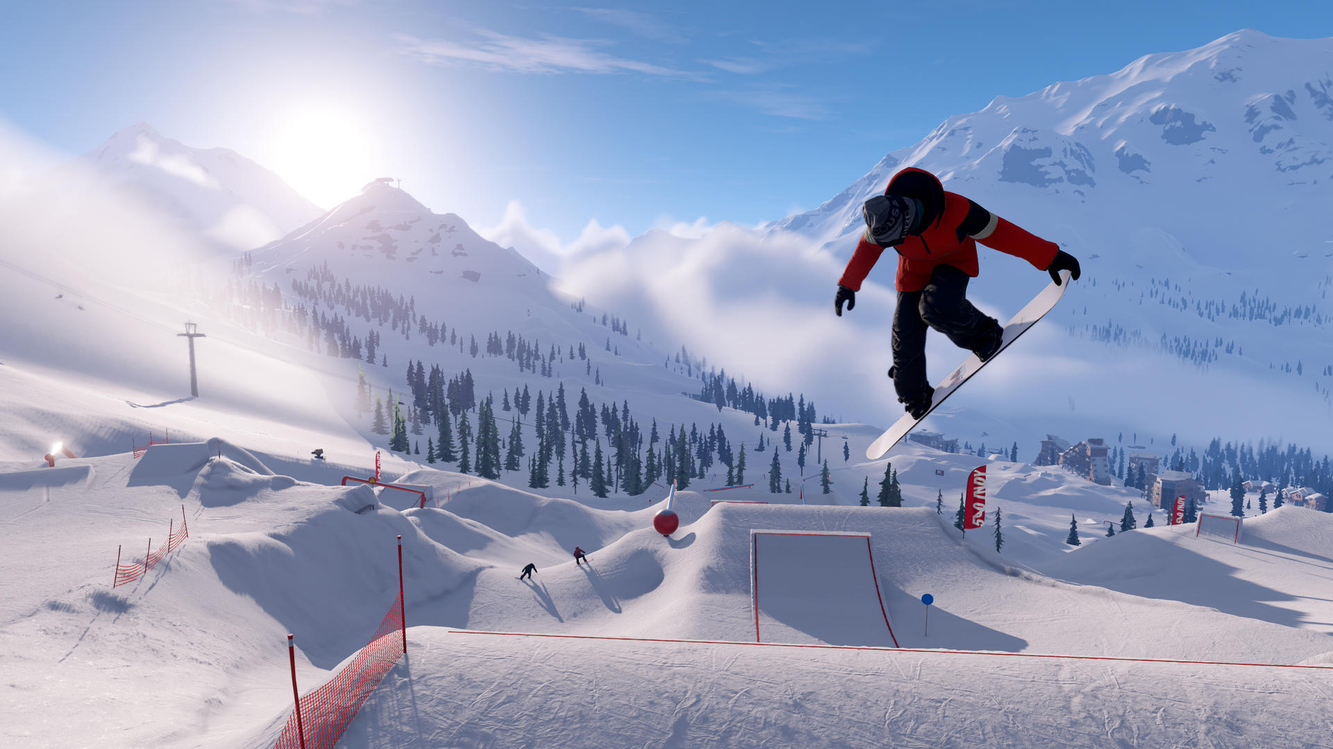 Ein Snowboarder springt in die Luft mit roter Jacke, blauem Himmel und schneebedeckten Bergen. Ein Skilift und kleine Gebäude sind sichtbar.
