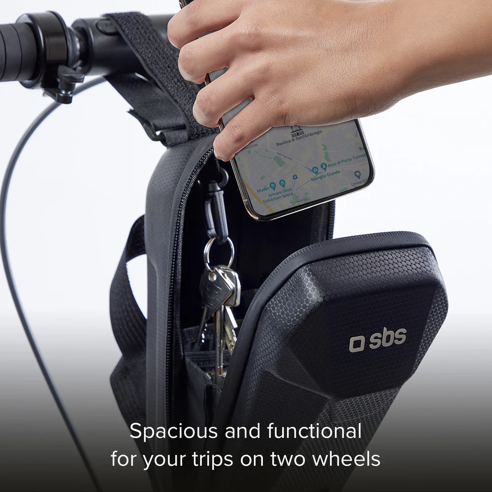 Hand legt ein Telefon mit Karte in eine schwarze Fahrradtasche. Schlüssel sind innen befestigt. Die Tasche ist am Lenker befestigt.